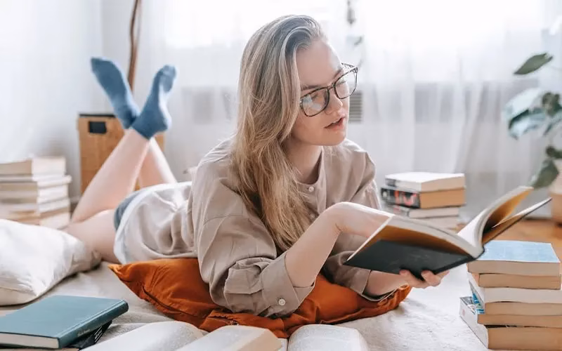 A girl reading a book in her home | Self Improvement Books for Women in 2026